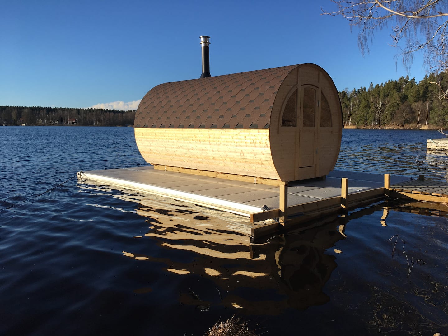 Bästa bastun – tunnformad flytande bastu på Borsöknasjön en solig dag